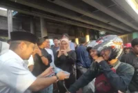 Keterangan foto :Tampak Pasha Ungu sedang membagikan takjil kepada pengendara roda empat, Sabtu (1/4/2023)