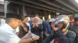 Keterangan foto :Tampak Pasha Ungu sedang membagikan takjil kepada pengendara roda empat, Sabtu (1/4/2023)