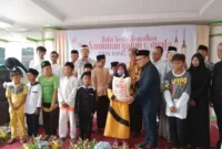 Foto: Ketua DPRD Kabupaten Tangerang, H Kholid Ismail (Pakai jas hitam) saat memberikan paket sembako kepada anak yatim.