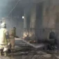 Keterangan Foto: Petugas Pemadam Saat Sedang Melakukan Pendinginan di area kebakaran pabrik oil pada Kamis,(6/4).