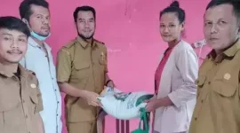 Poto : Sekdes, Ekbang dan Perwakilan PT Pos saat membagikan beras 