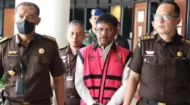 Keterangan Foto : Jhonny plate Menkominfo usai diperiksa mengenakan rompi khas Kejagung dan tangan terborgol.