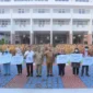 Keterangan Foto: secara simbolis santunan jaminan kematian senilai Rp. 42.000.000,- dan jaminan kecelakaan kerja senilai Rp. 1.167.000,- kepada perwakilan keluarga Tenaga Harian Lepas (THL) di Lingkup Pemerintah Kota Tangerang saat apel pagi, Senin (24/07).