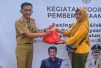 Camat Zam Zam Manohara saat memberikan paket sembako di acara bazar murah, Senin (1/4).