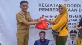 Camat Zam Zam Manohara saat memberikan paket sembako di acara bazar murah, Senin (1/4).
