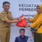 Camat Zam Zam Manohara saat memberikan paket sembako di acara bazar murah, Senin (1/4).