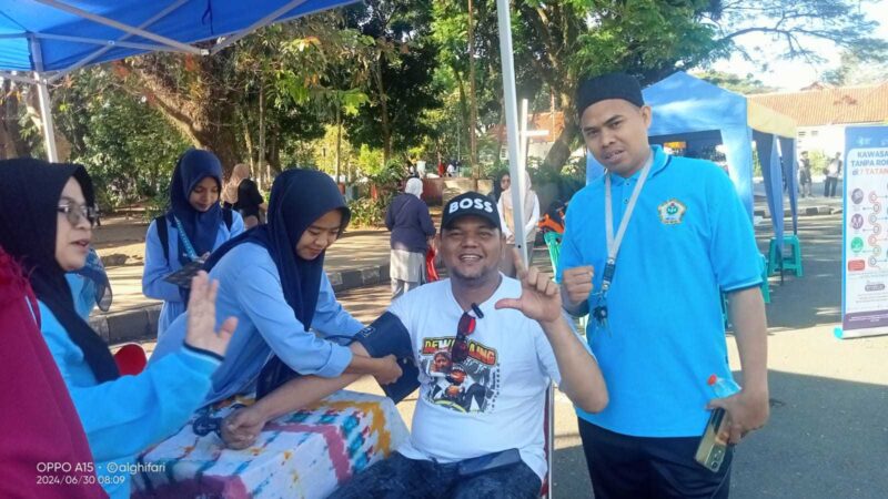 Keterangan poto : Suasana team kesehatan saat melakukan pemeriksaan kepada salah satu masyarakat saat kegiatan Pemeriksaan Kesehatan secara massal yang di gelar SMK PGRI Rangksbitung dalam rangka ikut memeriahkan HUT Bhayangkara ke 78 Tahun. di Alun - alun Rangkasbitung