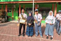 Keterangan poto : Kepala SMK PGRI Rangkasbitung, Dini Hipdiani, M. Ps, saat menyambu, Abu dan Siti, peraih juara 1 Lomba Panjat Tebing antar Pelajar Tingkat Kabupaten Lebak di halaman Sekolah pada 27/10/2024