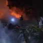 Damkar Kodim 0601/Pandeglang bersama warga setempat dalam menangani musibah kebakaran yang melanda Kampung Ciwangun, Desa Sukajadi, Kecamatan Cibaliung, pada Jumat (10/7/2026) malam.
